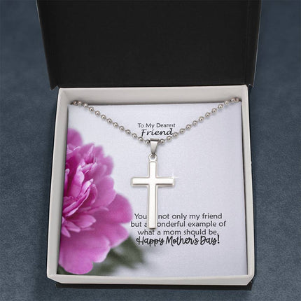 Polished stainless steel cross necklace with ball chain displayed in a mahogany luxury gift box with a To My Dearest Friend Happy Mother's Day message card and pink peony flower background.