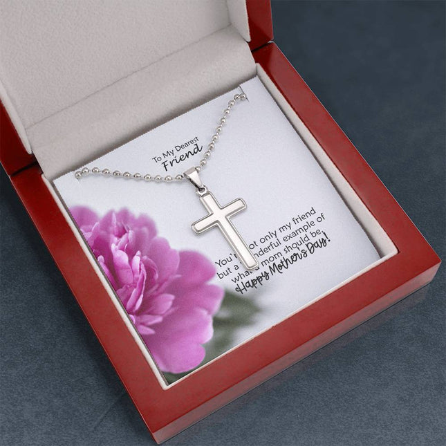 Polished stainless steel cross necklace with ball chain displayed in a mahogany luxury gift box with a To My Dearest Friend Happy Mother's Day message card and pink peony flower background.