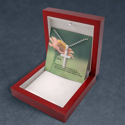 Polished stainless steel cross necklace with ball chain displayed in a luxury gift box with a To My Mom May All the Love You Gave Come Back Hundredfold Happy Mother's Day message card and pink zinnia flower background.