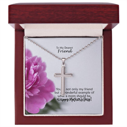 Polished stainless steel cross necklace with ball chain displayed in a mahogany luxury gift box with a To My Dearest Friend Happy Mother's Day message card and pink peony flower background.