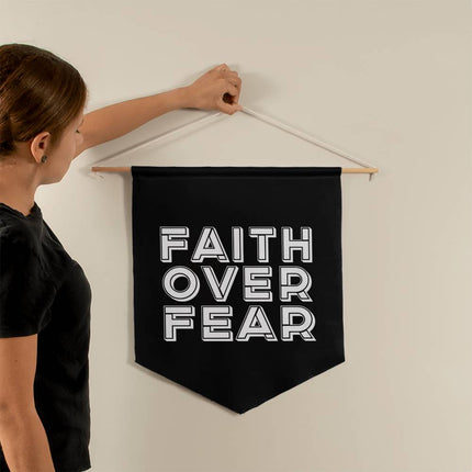 Faith over fear wall pennant with bold white outlined lettering on black background – 21x18 Christian wall decor