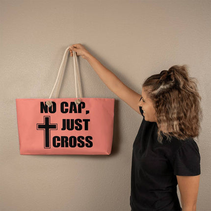 Pink weekender tote bag with “No Cap, Just Cross” black text and cross icon – Christian travel tote with rope handles
