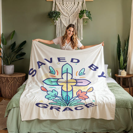 Saved by grace coral fleece blanket with colorful cross and floral accents on cream background – Christian cozy throw