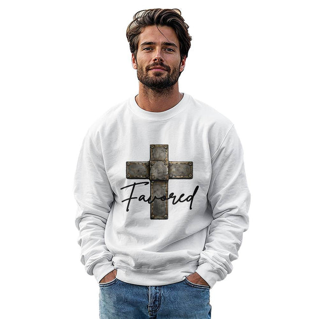Man wearing a white unisex crewneck sweatshirt featuring a vintage stone-tile riveted cross graphic with the word "Favored" in black script on the front, styled against a clean white background.