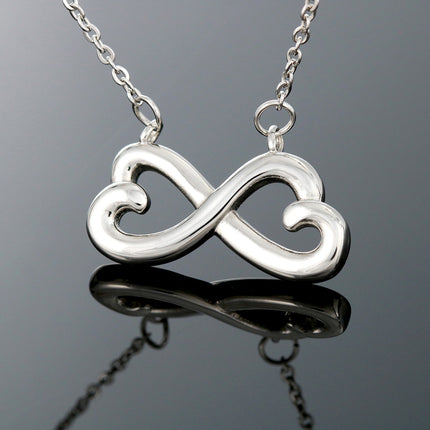 Heart-shaped infinity endless love necklace in white gold finish held in hands, displayed in a gift box with a Dear Mother-in-Law Happy Mother's Day message card and sunflower floral background.