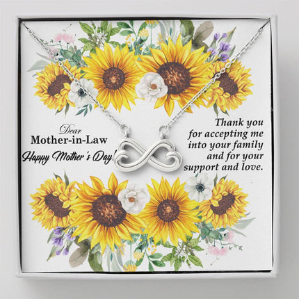 Heart-shaped infinity endless love necklace in white gold finish held in hands, displayed in a gift box with a Dear Mother-in-Law Happy Mother's Day message card and sunflower floral background.