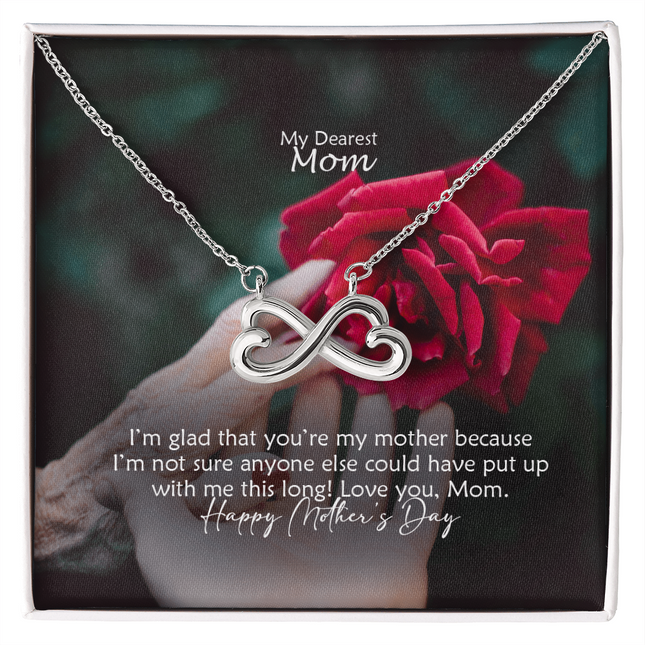 Heart-shaped infinity endless love necklace in white gold finish held in hands, displayed in a gift box with a My Dearest Mom Happy Mother's Day message card and red rose background.