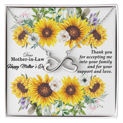 Heart-shaped infinity endless love necklace in white gold finish held in hands, displayed in a gift box with a Dear Mother-in-Law Happy Mother's Day message card and sunflower floral background.