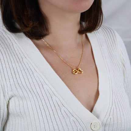 Heart-shaped infinity endless love necklace in white gold finish held in hands, displayed in a gift box with a Dear Mother-in-Law Happy Mother's Day message card and sunflower floral background.