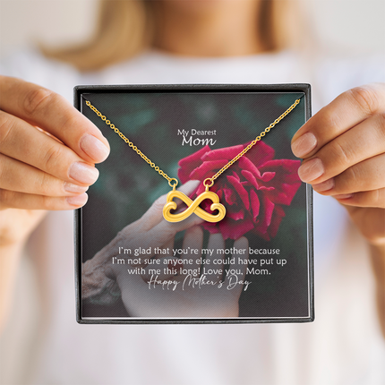 Heart-shaped infinity endless love necklace in white gold finish held in hands, displayed in a gift box with a My Dearest Mom Happy Mother's Day message card and red rose background.