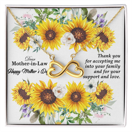 Heart-shaped infinity endless love necklace in white gold finish held in hands, displayed in a gift box with a Dear Mother-in-Law Happy Mother's Day message card and sunflower floral background.